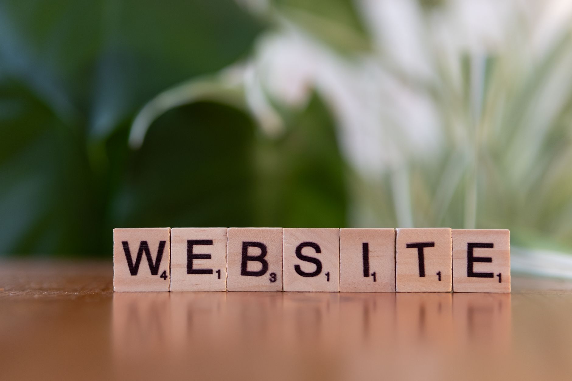 scrabble tiles spelling website on wooden surface